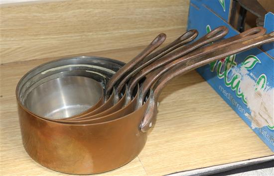 A set of five graduated copper saucepans